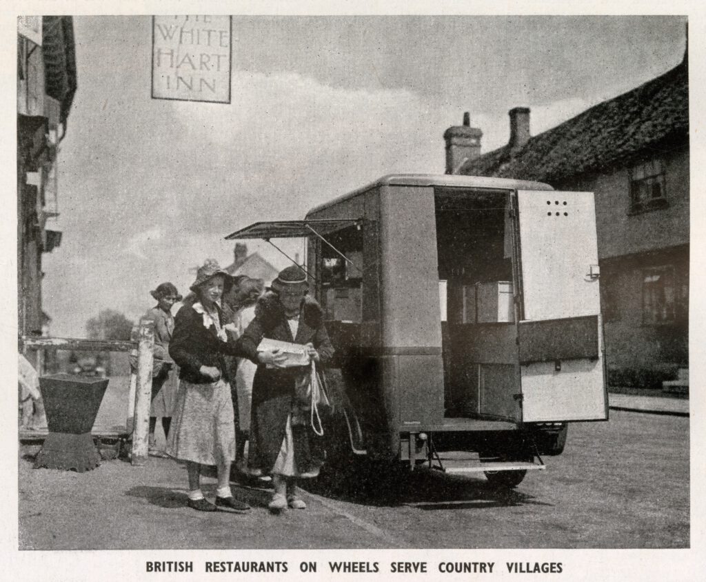 Several customers gather at a mobile canteen van in a residential street in the 1940s.