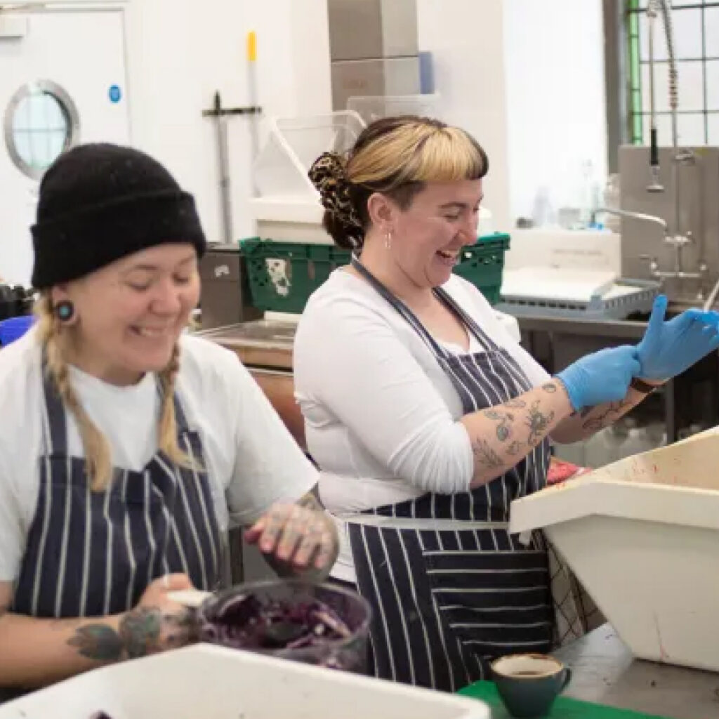 Two young female workers at work preparing food