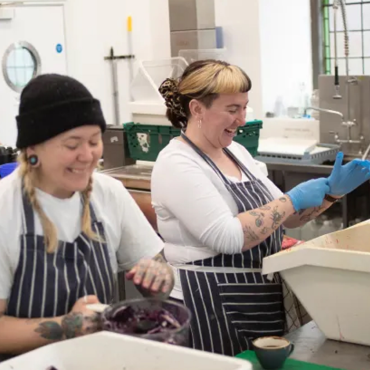 Two young female workers at work preparing food