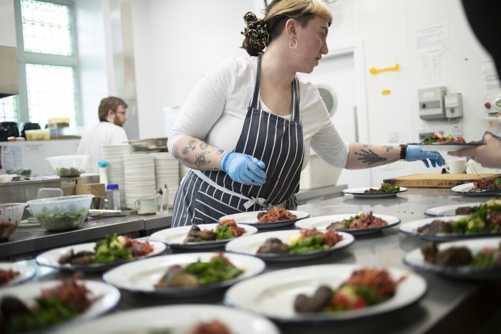 Kitchen worker prepping plates to go out to customers